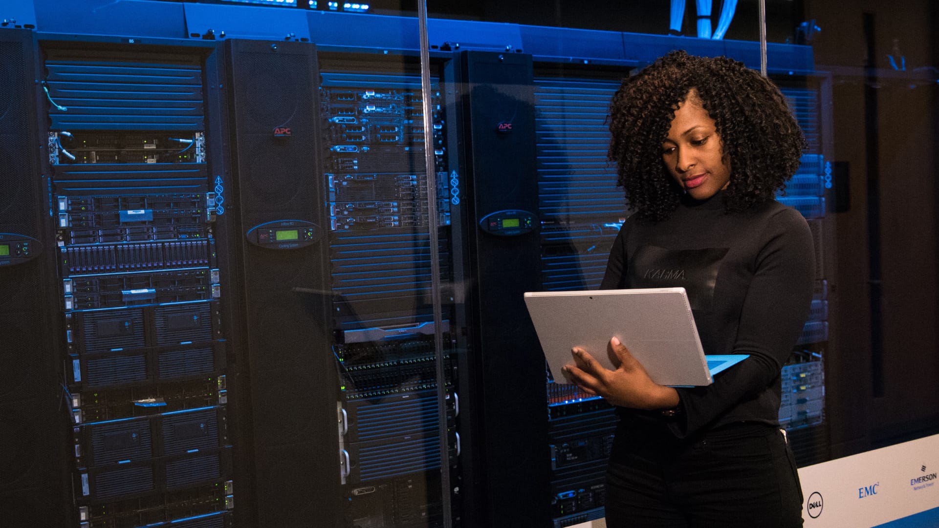 woman in a data center working on a laptop.