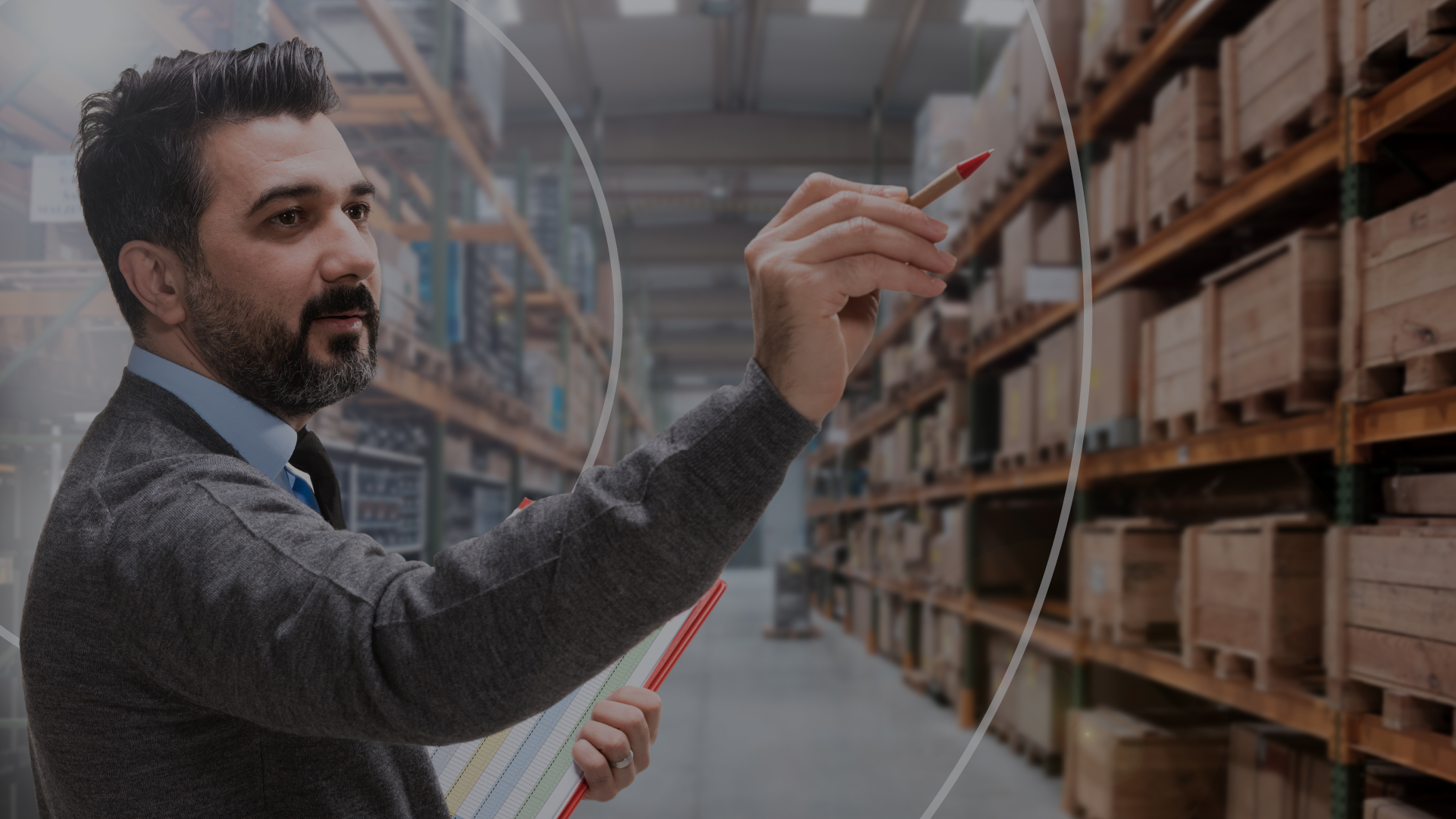 Man in a warehouse holding a pen checking inventory