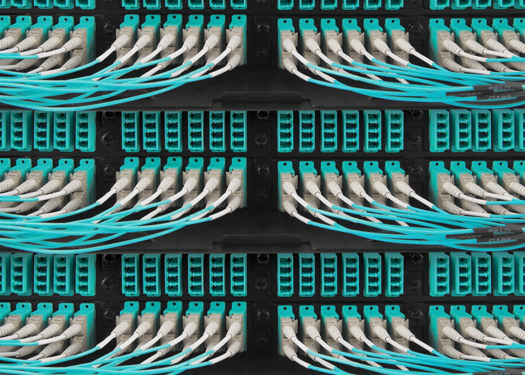 A series of PON cables plugged into data center equipment