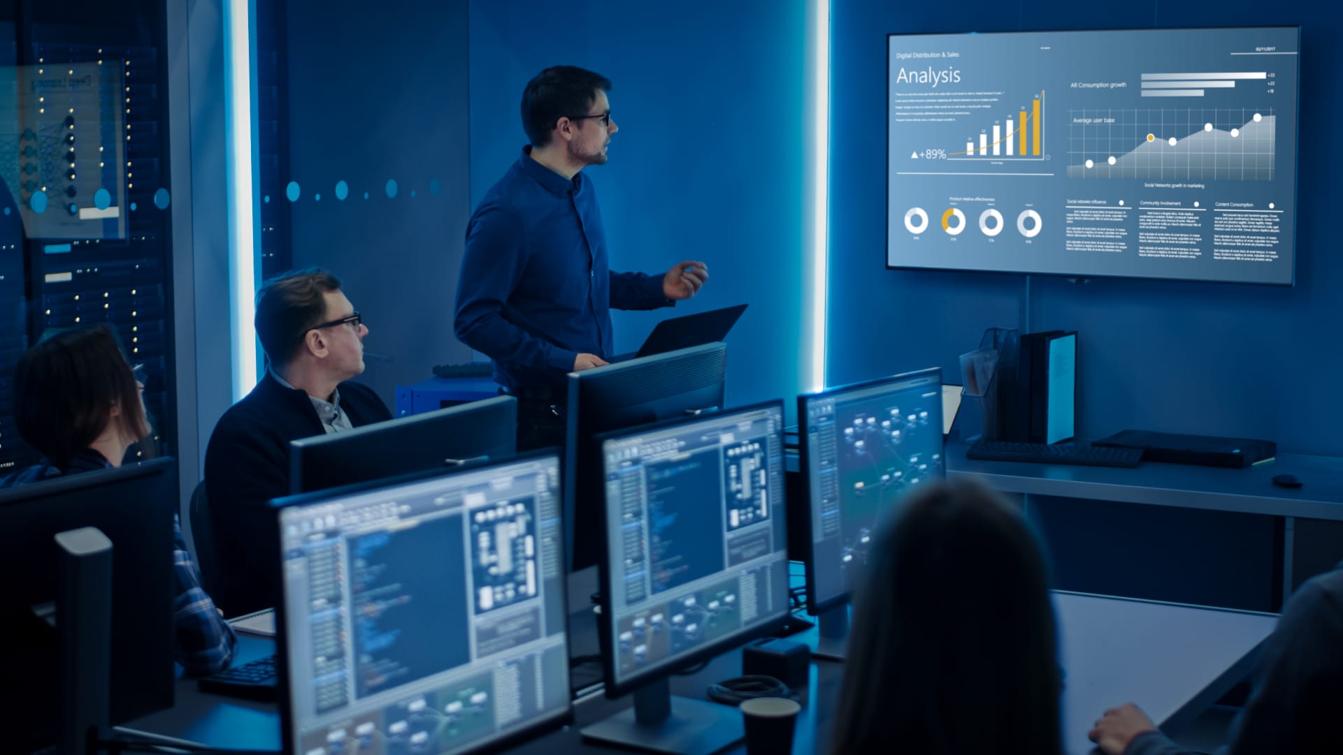 People in a high-tech conference room viewing statistics on a big screen